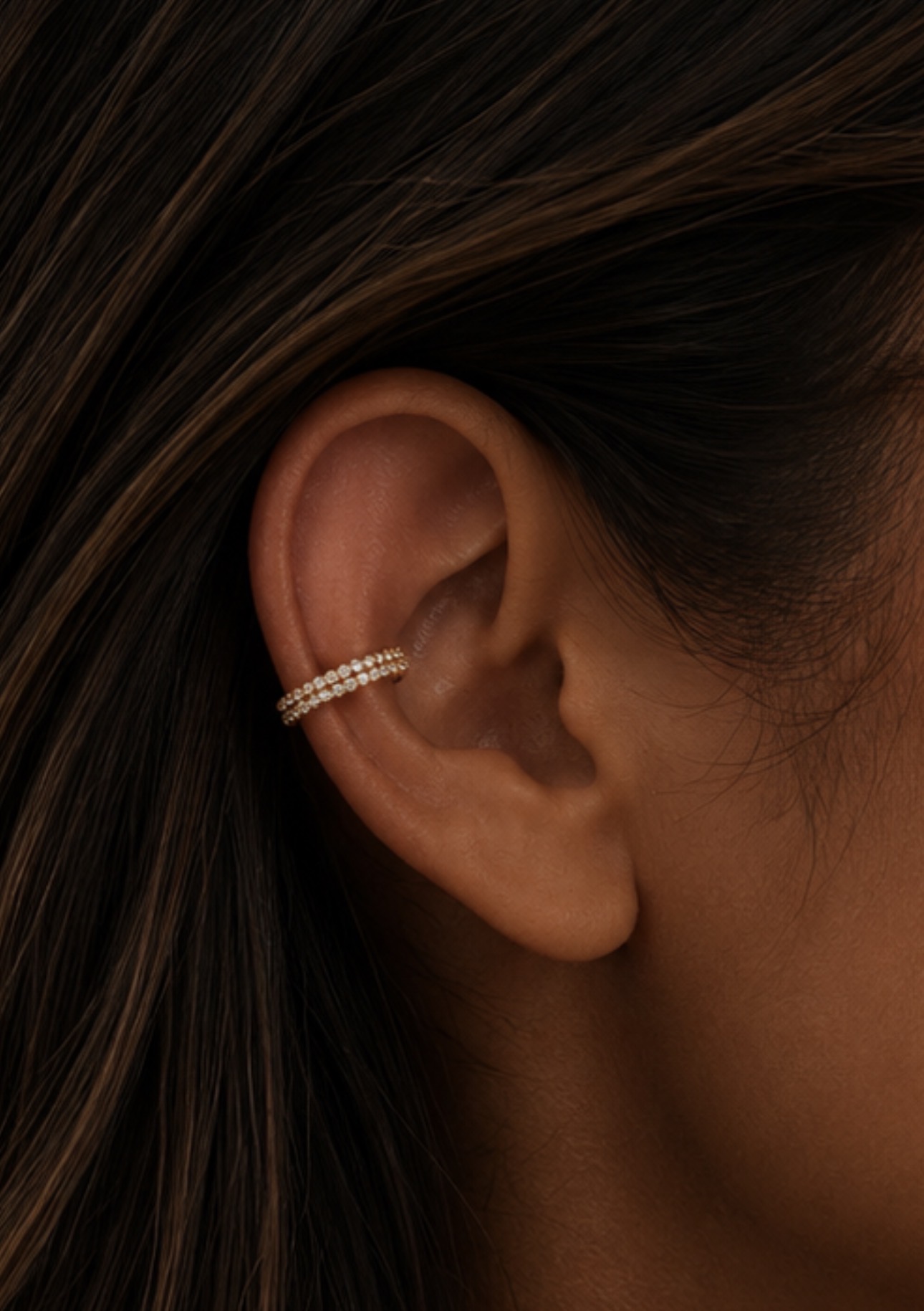 Piercing conch com ear cuff duplo cravejado em ouro na cartilagem central da orelha — Luquini Estética Auricular