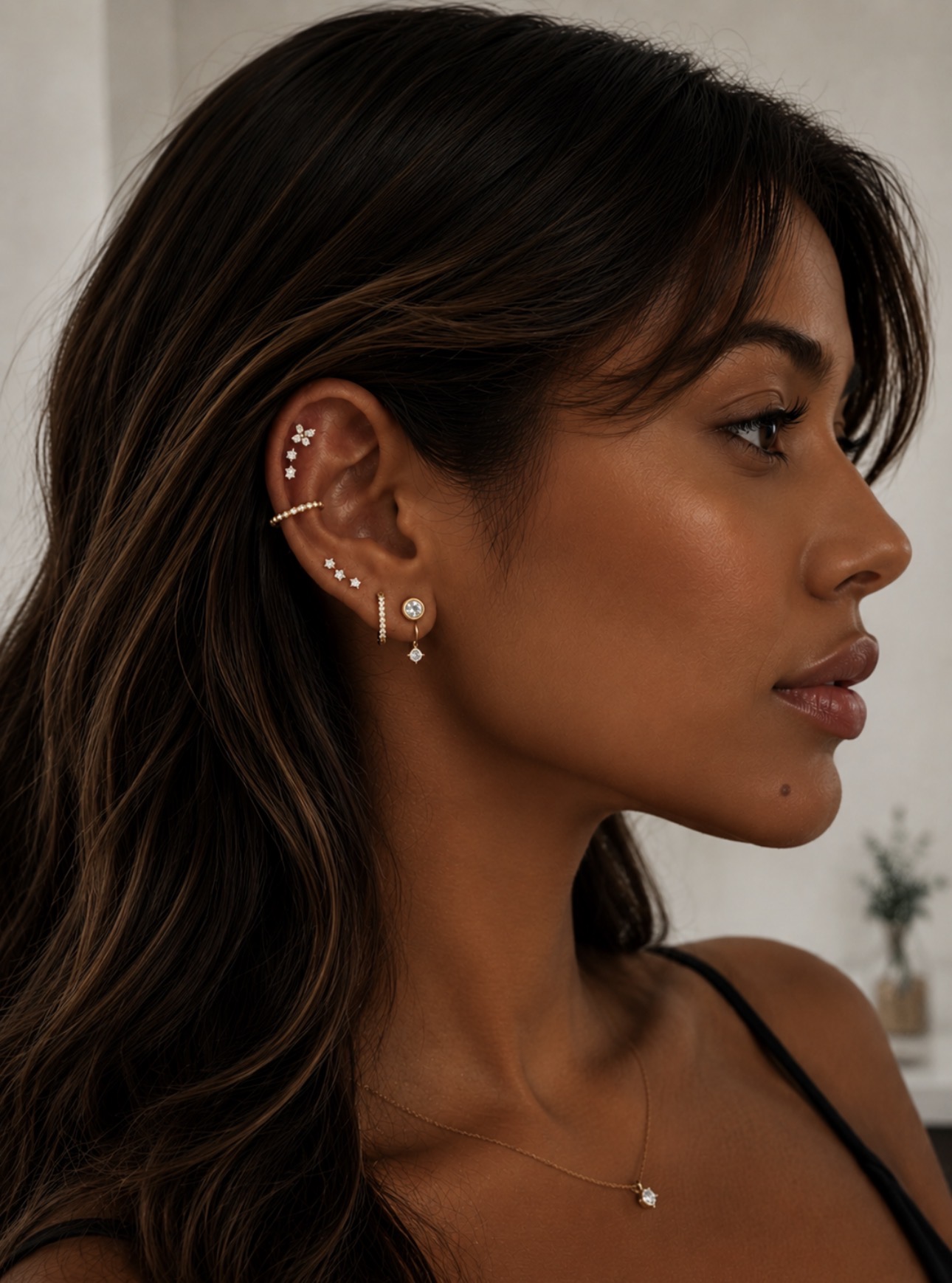Projeto auricular com piercings humanizados em ouro — composição em helix, lóbulo e ear cuff realizada pela Luquini Estética Auricular no Rio de Janeiro