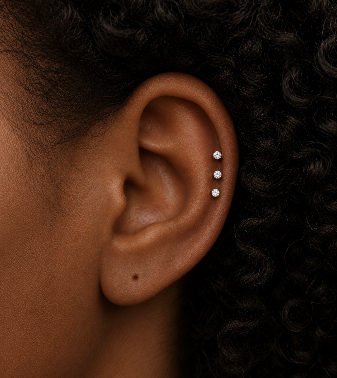Composição midhelix triplo (australianos) com três piercings de zircônia alinhados na cartilagem da orelha — Luquini Estética Auricular